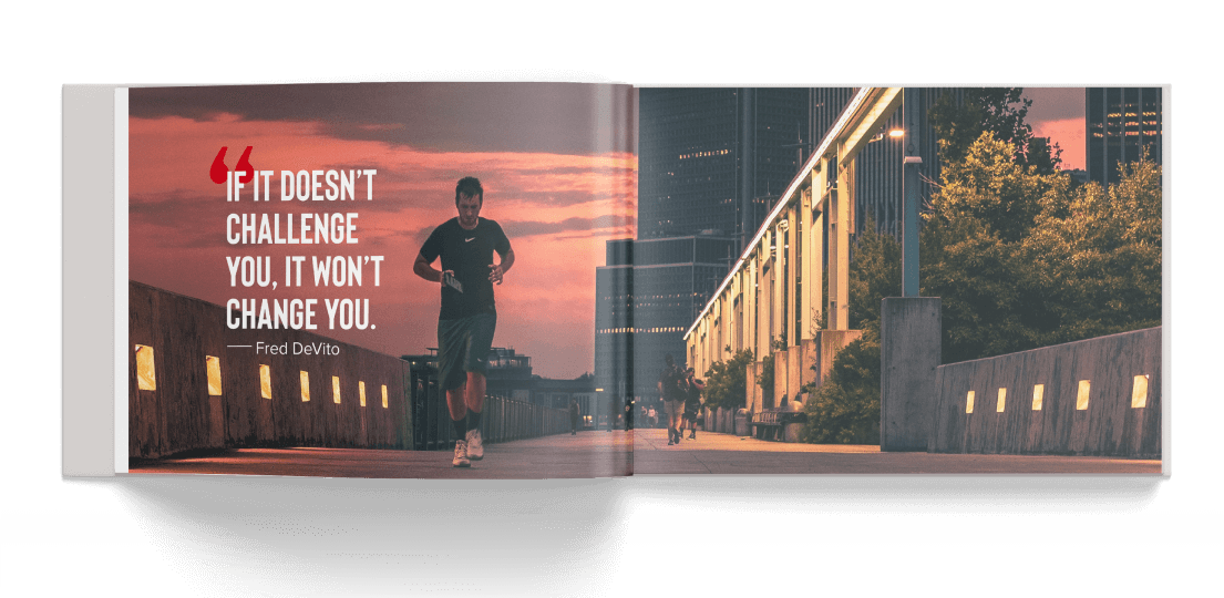 Coffee table book open to a photo of a runner in front of a sunset with a quote overlaid reading "If it doesn't challenge you, it won't change you."
